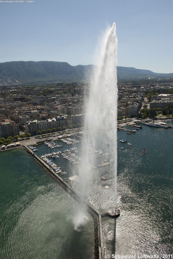 Genf / Genève, Seebecken, 'Jet d'eau' (Position: 2'500'996.71, 1'118'130.85) Der weltbekannte Jet d'eau in Genf ist eine Touristenattraktion, deren Anfänge auf das späte 19. Jahrhundert (1886) zurückgeht. Der weisse Wasservorhang über der Jetée des Eaux-Vives ist 140 Meter hoch, stösst 500 Liter Wasser/Sekunde mit einer Geschwindigkeit von 200 km/h aus. Die Fontäne ist fast 50 Meter höher als die Freiheitsstatue in New York.